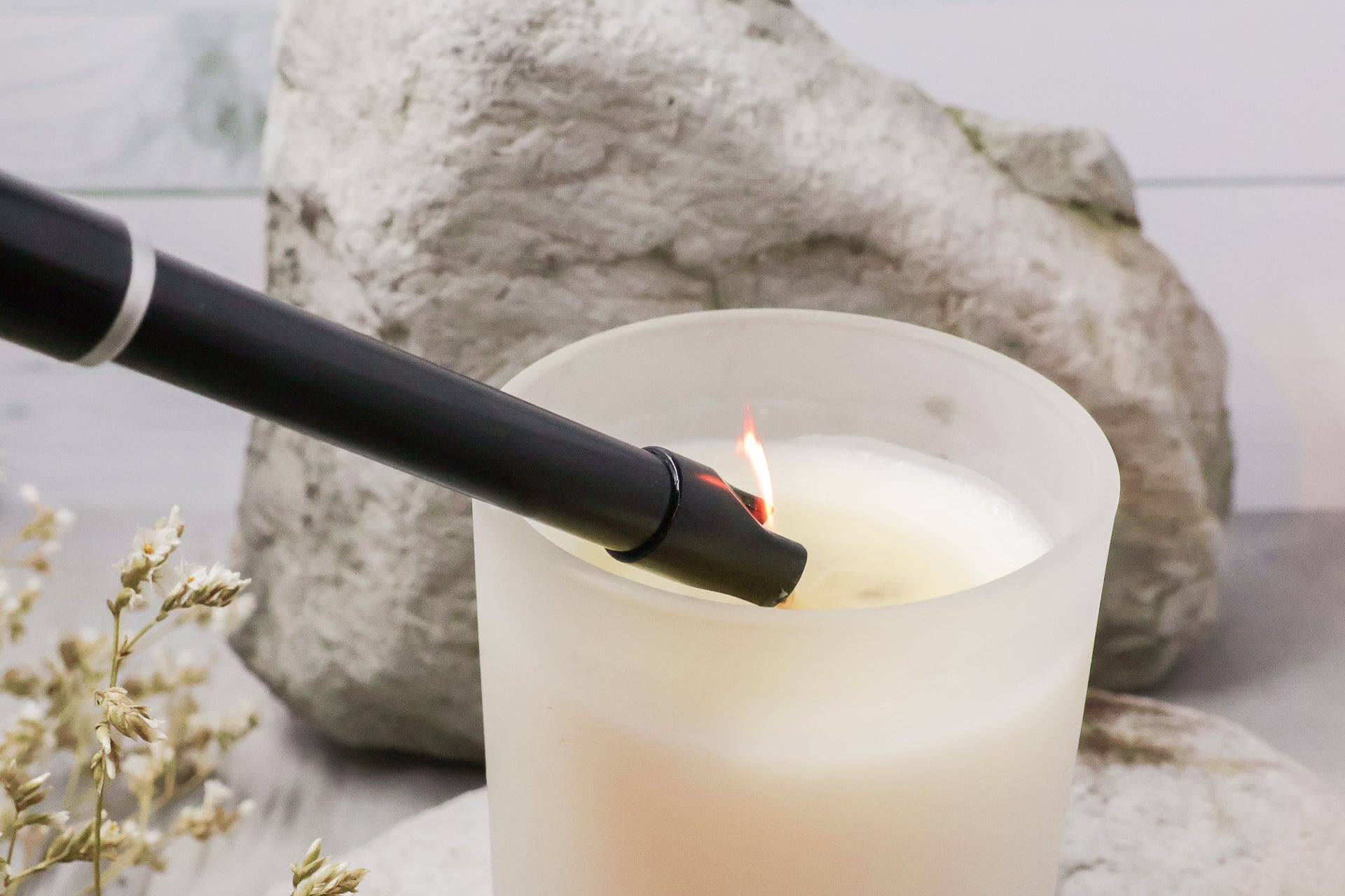 Lighter with a flame lighting a Crystl. Candle