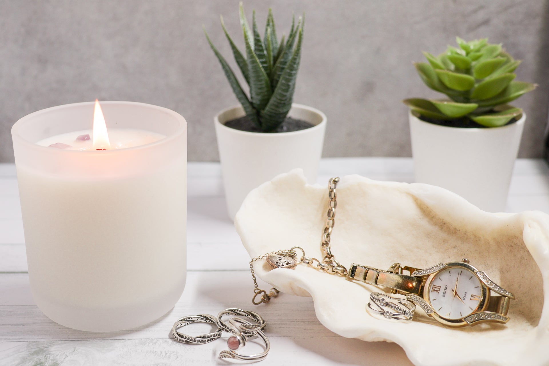 Crystal infused candle on an aesthetic countertop with a watch